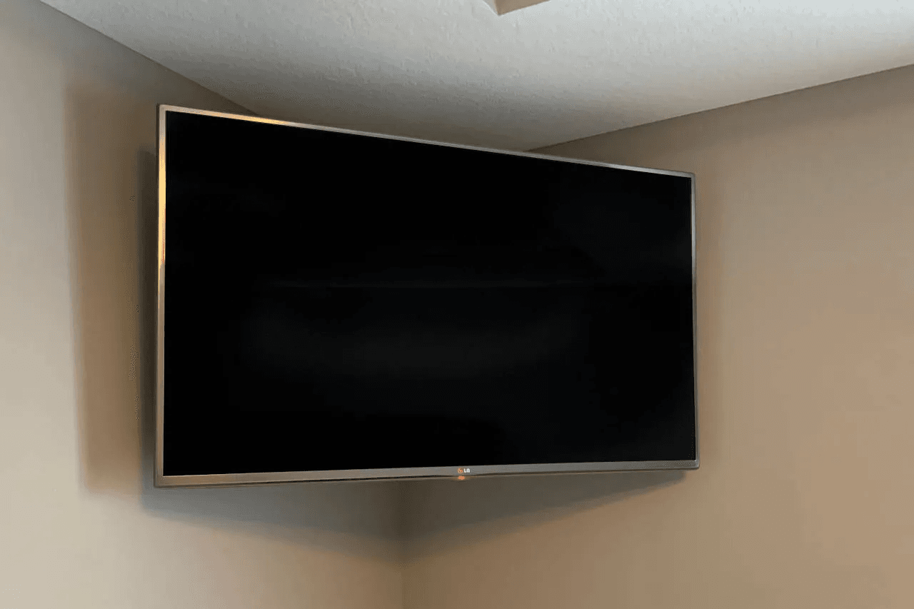 A TV mounted in the corner of a room where two walls meet.