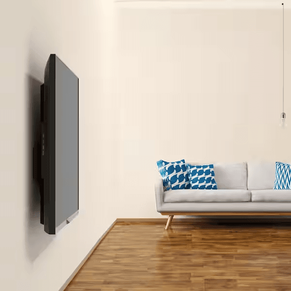 A TV mounted flat and close to the wall in a living room, viewed at an angle, with a sofa nearby.
