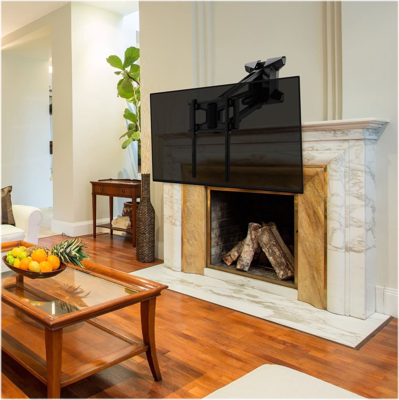 A TV mounted above a marble fireplace mantel on a pull-down mount.